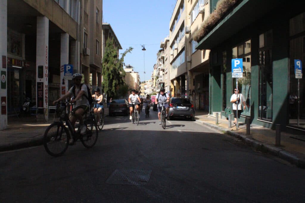 Photo grand angle de plusieurs personnes roulant dans la rue en vélo